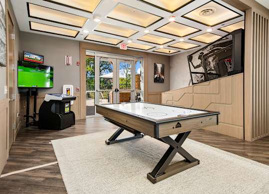 A room with a pool table and a television.