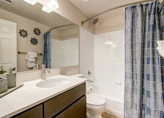 A bathroom with a sink, toilet, and shower.