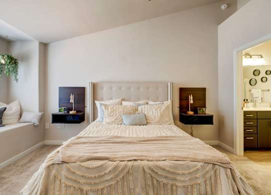 A bed with a white comforter and pillows in a bedroom.