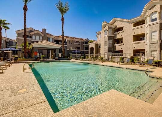 A large swimming pool in front of apartment buildings.