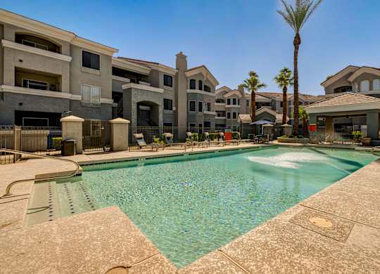A swimming pool in front of apartment buildings.