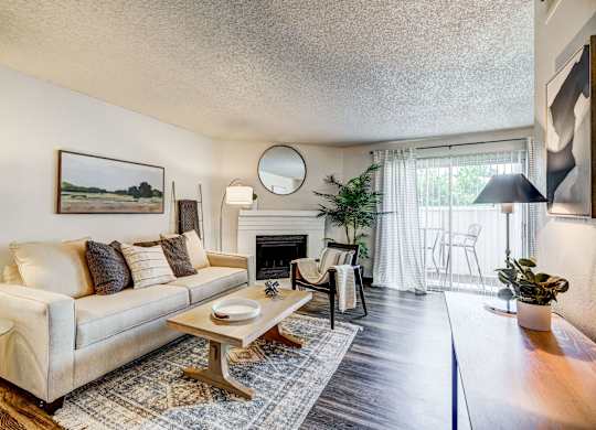 A living room with a couch, a coffee table, and a fireplace.