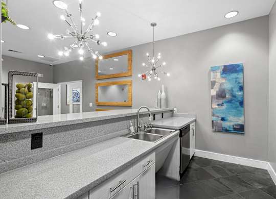 A modern kitchen with a large island and a chandelier.