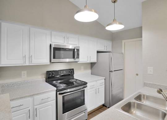 A kitchen with white cabinets and stainless steel appliances.