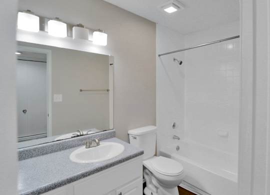 A white toilet sits next to a sink in a bathroom.