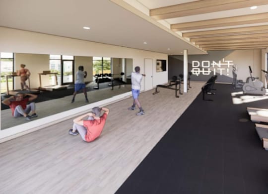 A gym with a black mat and people working out.