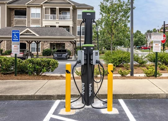 A black electric vehicle charging station sits in a parking spot.
