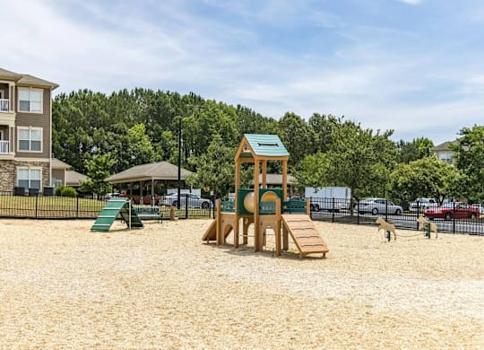 A playground with a wooden structure and a green slide.