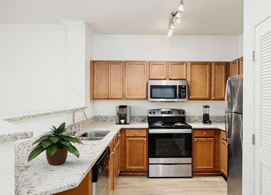 A kitchen with wooden cabinets and stainless steel appliances.