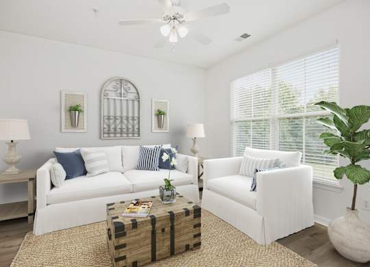 A living room with white furniture and a ceiling fan.