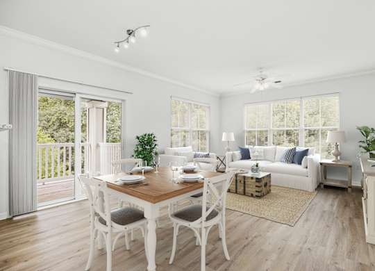 A dining room with a wooden table and white chairs.