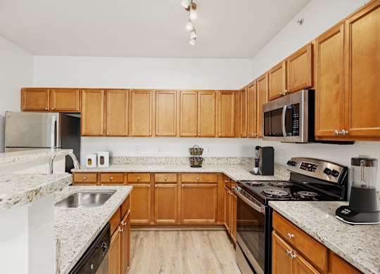 A kitchen with wooden cabinets and granite countertops.