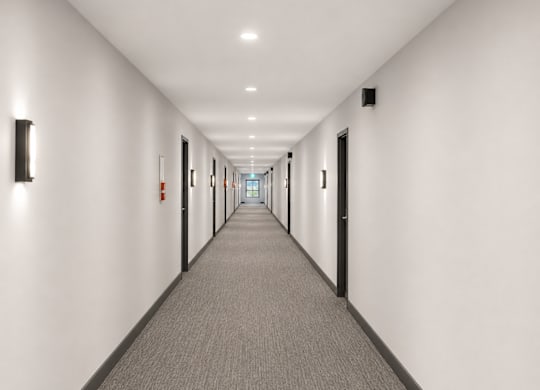 A long hallway with carpeted floors and white walls.