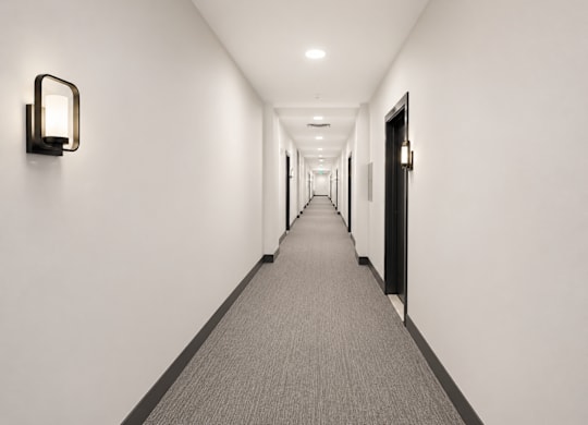 A long hallway with a carpeted floor and white walls.