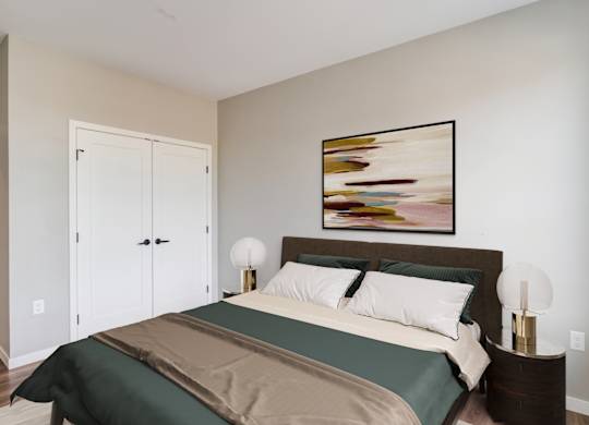 a bedroom with a large bed and two night stands with lamps at Harper Apartments in St Paul, MN