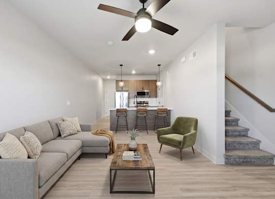 A living room with a grey couch, a green armchair, and a wooden coffee table.