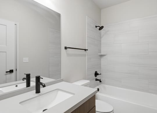 A white bathroom with a sink, toilet, and bathtub.