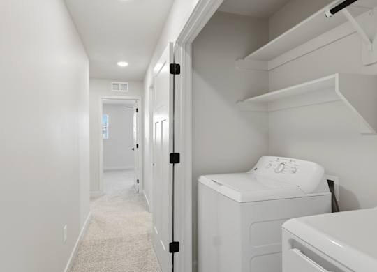 A white laundry room with a washer and dryer.