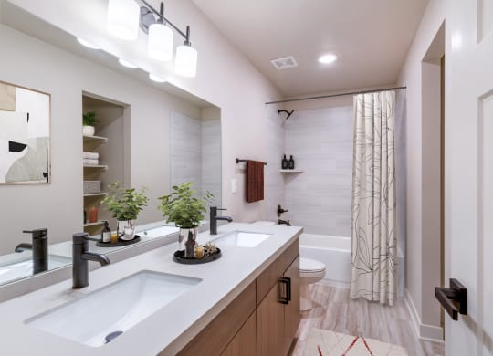 Pet-Friendly Apartments In Raymore, MO - Bathroom With Designer LVT Floors, Large Garden Soaking Shower, Large Mirror, Custom Vanity Cabinets, And Upgraded Plumbing Fixtures.
