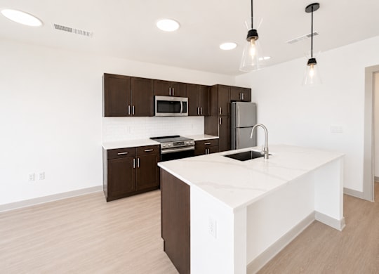A kitchen with brown cabinets and a white island.