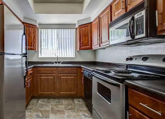 A kitchen with wooden cabinets and a black stove top oven.
