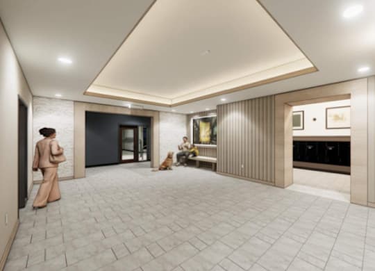 A dog is sitting on the floor of a spacious room with a fireplace.