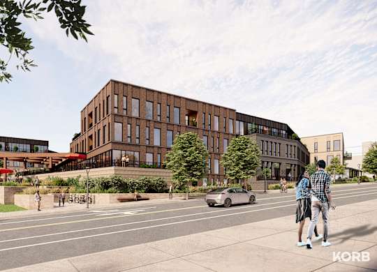 A street view of a modern building with people walking and riding bikes.