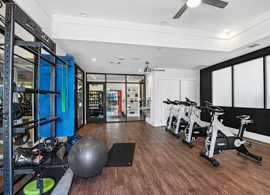 Markethaus 3700 Fitness Studio A gym with a variety of equipment including a stationary bike, a medicine ball, and a weight rack.