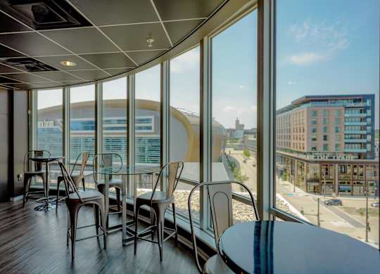 A room with a table and chairs with a view of the city.