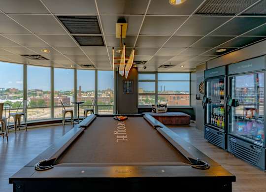 A pool table in a room with a view of the city.