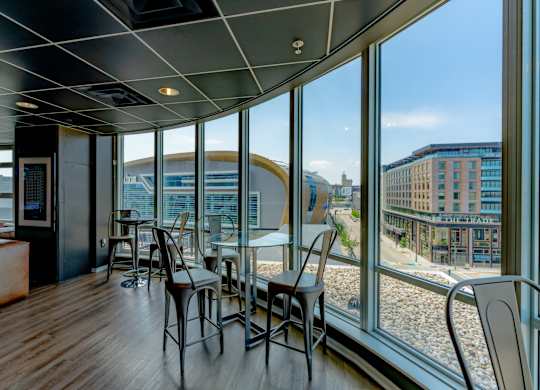 A room with a table and chairs with a view of the outside.