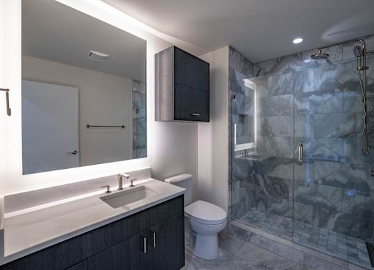 A bathroom with a sink, toilet, and shower.