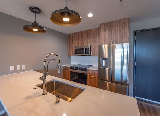 A modern kitchen with a sink and stainless steel appliances.
