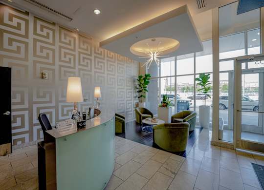 A reception area with a green desk and a black door.
