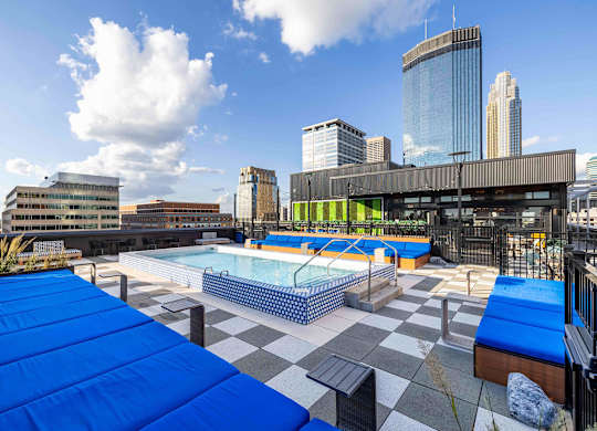 a pool on the roof of a building with a city in the background