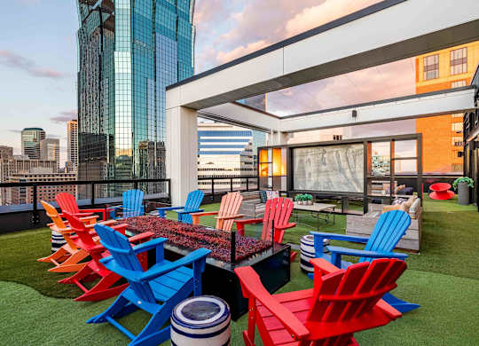 a terrace with red and blue chairs and a table