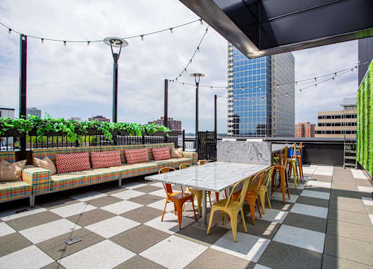 a rooftop patio with tables and chairs and a view of the city
