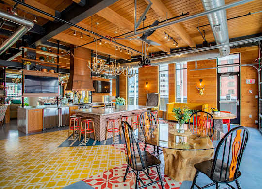 the kitchen and dining area of a loft with a table and chairs