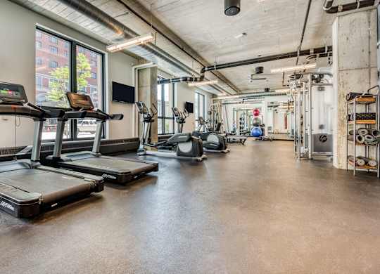 the gym with treadmills and weights at the belgard apartments