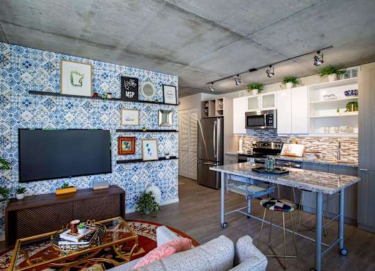 a kitchen and living room with blue and white tiles on the wall