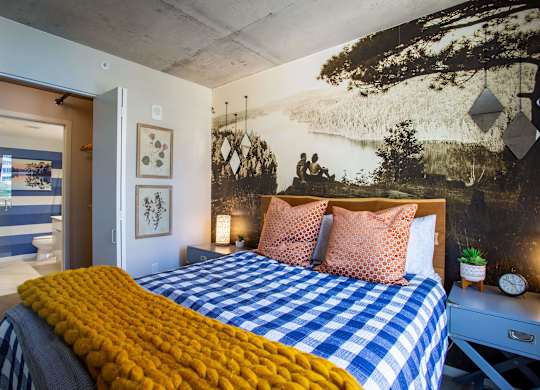 a bedroom with a bed and a mural on the wall