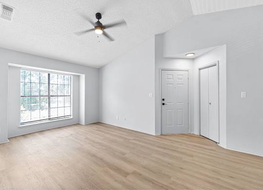 A room with a ceiling fan and two doors.