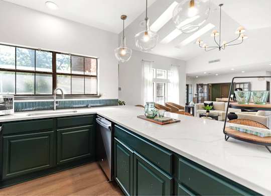 A kitchen with green cabinets and a white countertop.