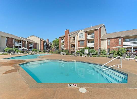 A swimming pool in front of apartment buildings.
