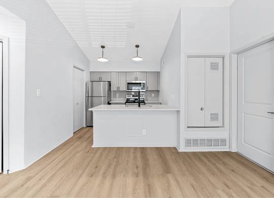 A kitchen with white cabinets and a white island.
