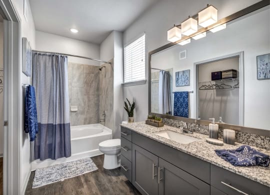 a bathroom with a shower and a toilet and a sink