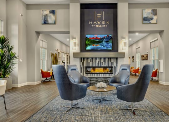a living room with chairs and a fireplace