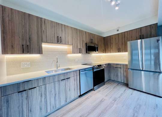 a kitchen with wooden cabinets and stainless steel appliances