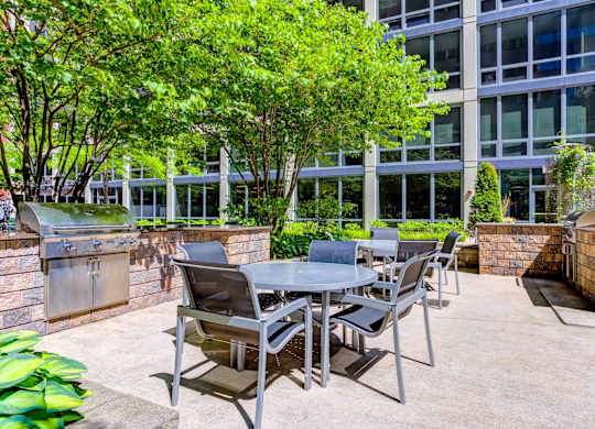 a patio with a table and chairs in front of a building