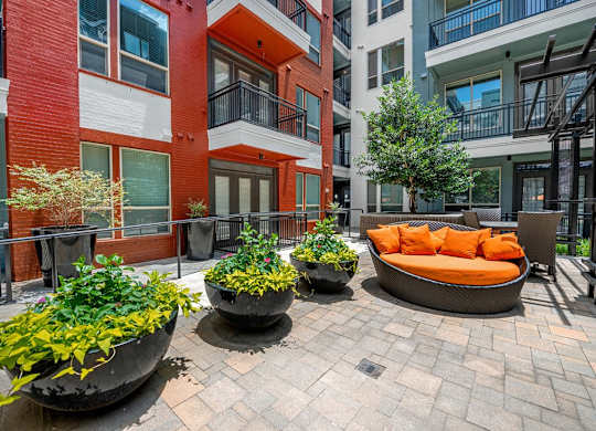 A courtyard with a bench and potted plants.